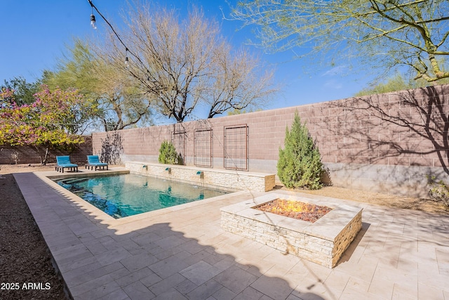 view of swimming pool featuring a fenced in pool, a fenced backyard, a patio, and a fire pit