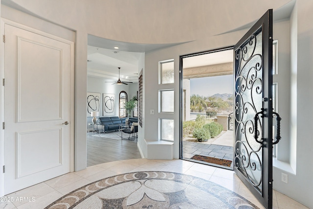 entryway featuring a healthy amount of sunlight, light tile patterned floors, and ceiling fan