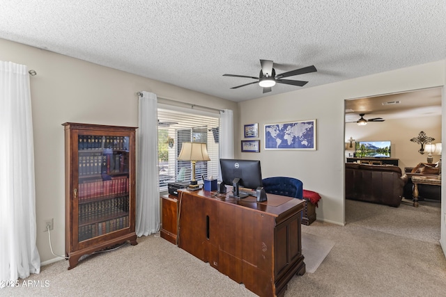 office with light carpet, ceiling fan, and a textured ceiling