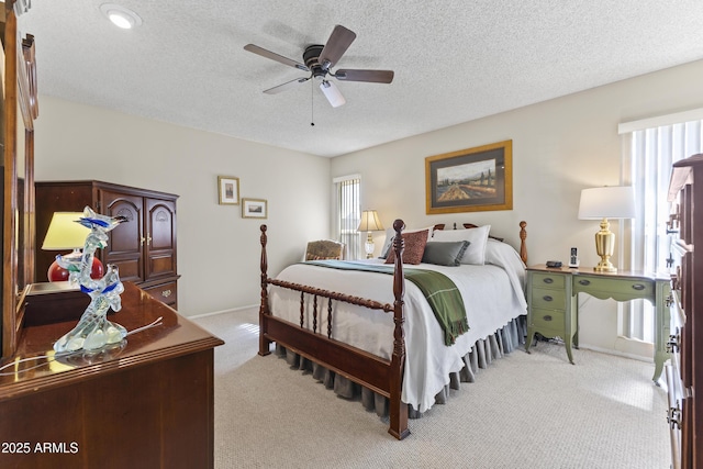 bedroom featuring multiple windows, light carpet, a textured ceiling, and ceiling fan