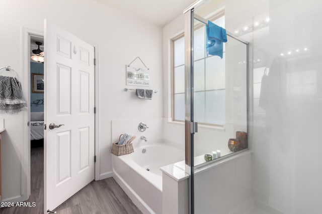 bathroom with shower with separate bathtub and hardwood / wood-style flooring