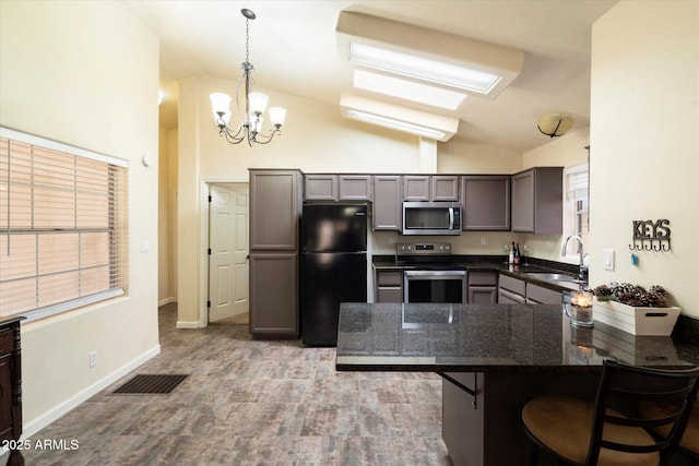 kitchen with a kitchen breakfast bar, kitchen peninsula, vaulted ceiling, sink, and stainless steel appliances