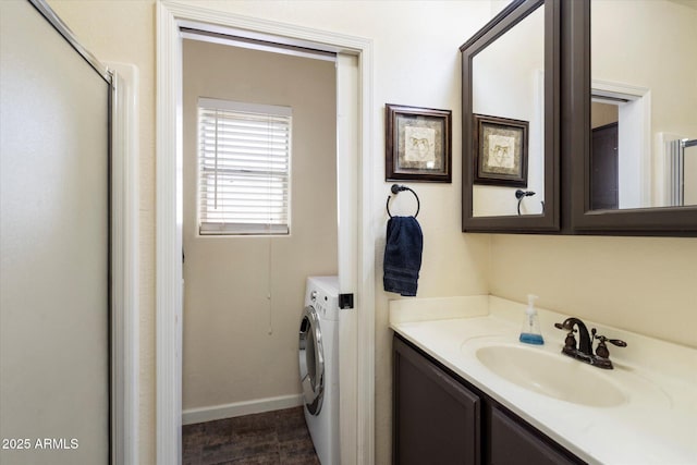 bathroom with hardwood / wood-style floors, an enclosed shower, washer / dryer, and vanity