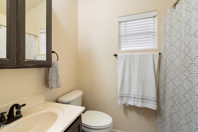 bathroom featuring curtained shower, toilet, and vanity