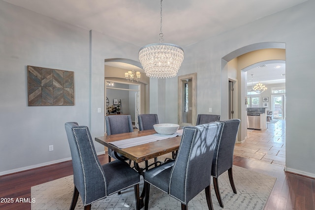 2735 E Flower Ct, Gilbert, AZ 85298 - dining space featuring arched walkways, a chandelier, baseboards, and wood finished floors