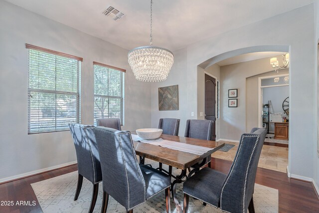 2735 E Flower Ct, Gilbert, AZ 85298 - dining area featuring a chandelier, arched walkways, dark wood-type flooring, and baseboards