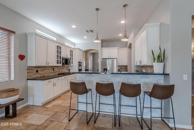 2735 E Flower Ct, Gilbert, AZ 85298 - kitchen featuring stainless steel appliances, a kitchen breakfast bar, tasteful backsplash, a peninsula, and recessed lighting