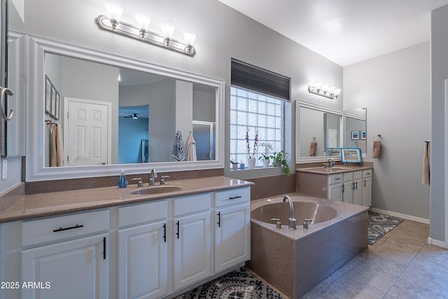 2735 E Flower Ct, Gilbert, AZ 85298 - bathroom featuring two vanities, a garden tub, ceiling fan, tile patterned floors, and baseboards