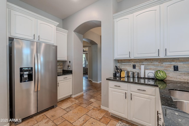 2735 E Flower Ct, Gilbert, AZ 85298 - kitchen featuring stainless steel fridge with ice dispenser, stone tile flooring, arched walkways, decorative backsplash, and white cabinetry