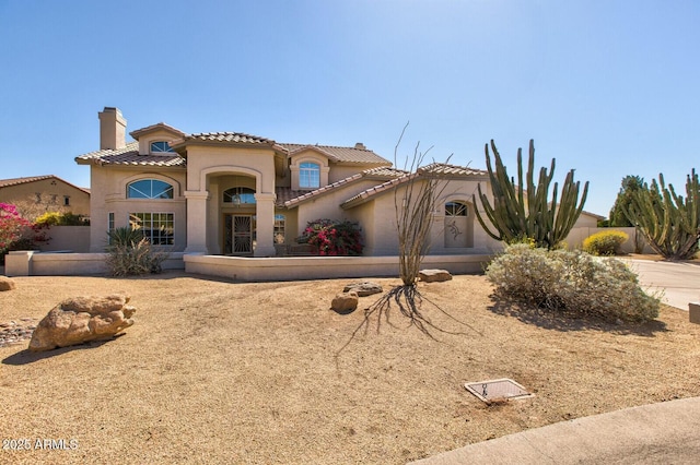 view of front of home featuring a chimney, a tiled roof, and stucco siding