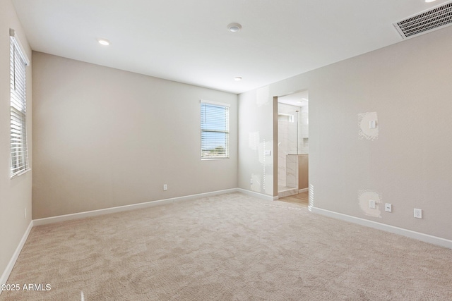 unfurnished bedroom with light carpet, visible vents, connected bathroom, and baseboards