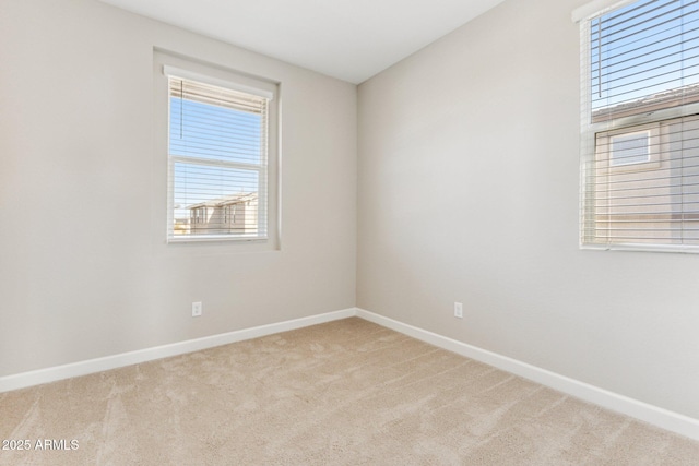 carpeted empty room featuring baseboards