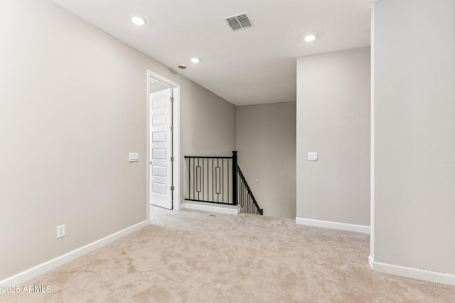 carpeted empty room featuring visible vents, recessed lighting, and baseboards