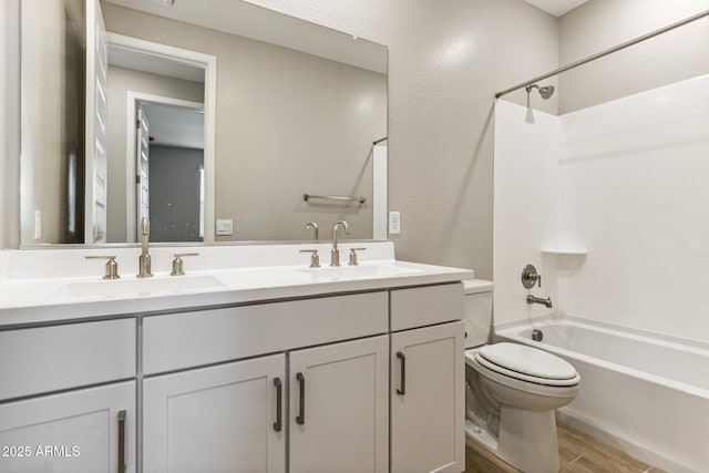 bathroom featuring a sink, toilet, wood finished floors, and double vanity