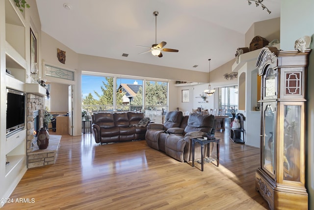 living room featuring ceiling fan with notable chandelier, high vaulted ceiling, and light hardwood / wood-style flooring