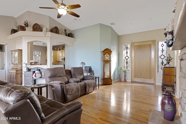 living room with light hardwood / wood-style floors, high vaulted ceiling, and ceiling fan