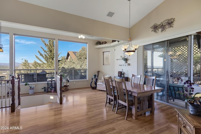 dining area with a chandelier, lofted ceiling, and hardwood / wood-style flooring