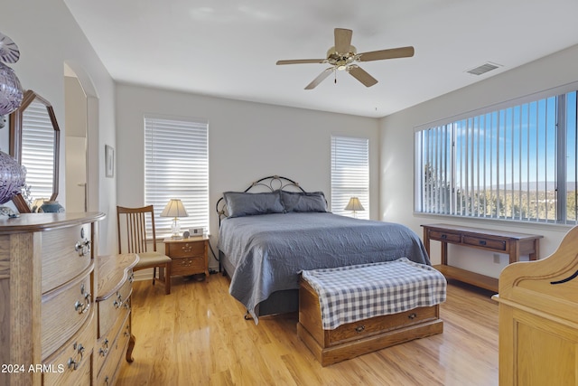 bedroom with multiple windows, ceiling fan, and light hardwood / wood-style floors