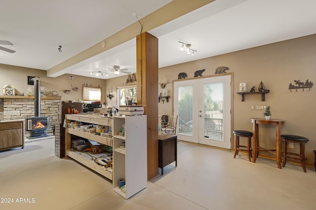 kitchen with french doors, a wood stove, plenty of natural light, and ceiling fan