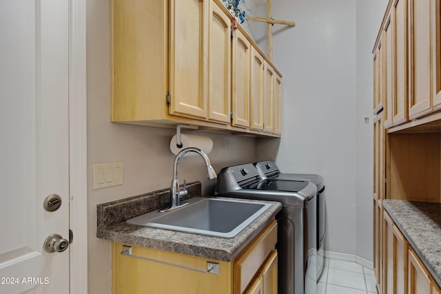 laundry room featuring washer and clothes dryer, cabinets, light tile patterned floors, and sink