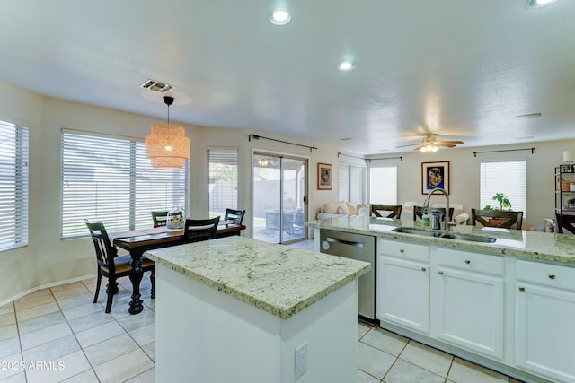 kitchen featuring a center island, visible vents, stainless steel dishwasher, open floor plan, and a sink