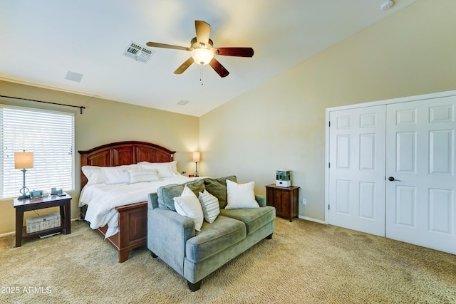 bedroom featuring visible vents, light colored carpet, ceiling fan, vaulted ceiling, and a closet