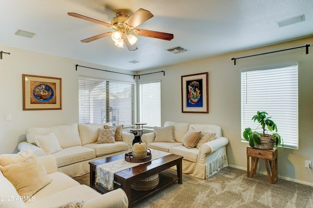 living room with carpet, visible vents, ceiling fan, and baseboards