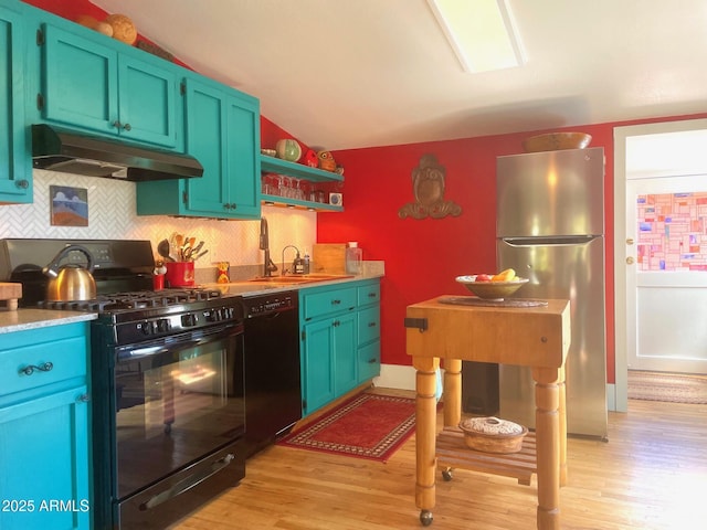1608 W W Blvd, Bisbee, AZ 85603 - kitchen featuring black appliances, under cabinet range hood, light wood-style floors, backsplash, and vaulted ceiling