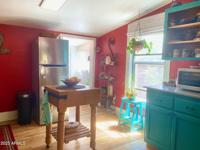 1608 W W Blvd, Bisbee, AZ 85603 - kitchen with stainless steel appliances, light wood finished floors, vaulted ceiling, and baseboards