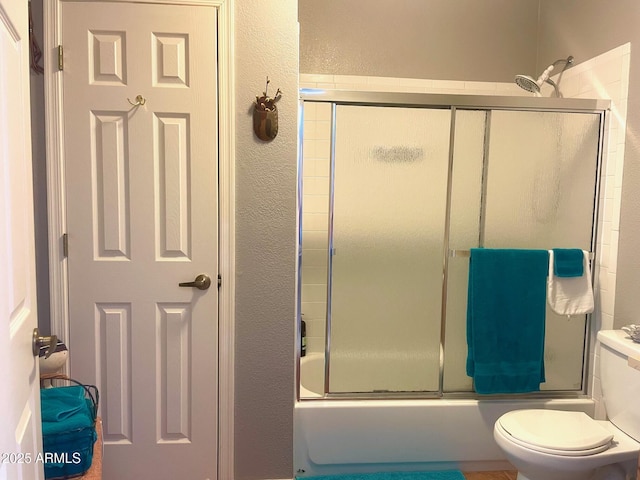 1608 W W Blvd, Bisbee, AZ 85603 - bathroom with a textured wall, toilet, and bath / shower combo with glass door