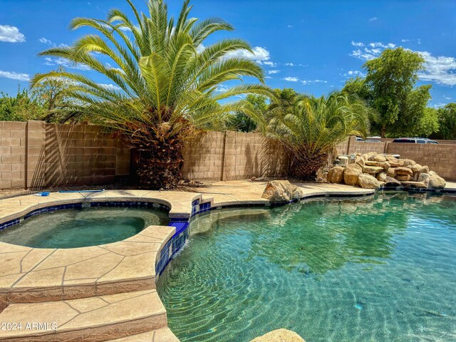 view of pool with an in ground hot tub