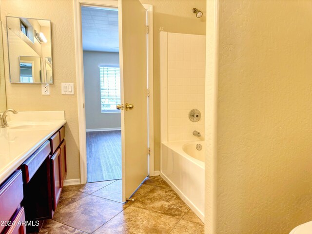 bathroom featuring tile patterned flooring, washtub / shower combination, and vanity