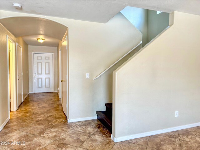 hall with tile patterned floors