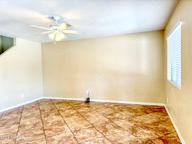 spare room featuring ceiling fan and tile patterned flooring