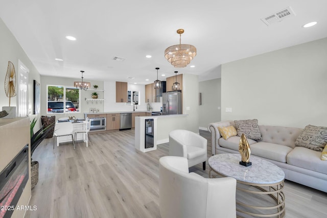 5236 S 19th Ave, Phoenix, AZ 85041 - living room featuring a chandelier, light wood-type flooring, recessed lighting, and wine cooler