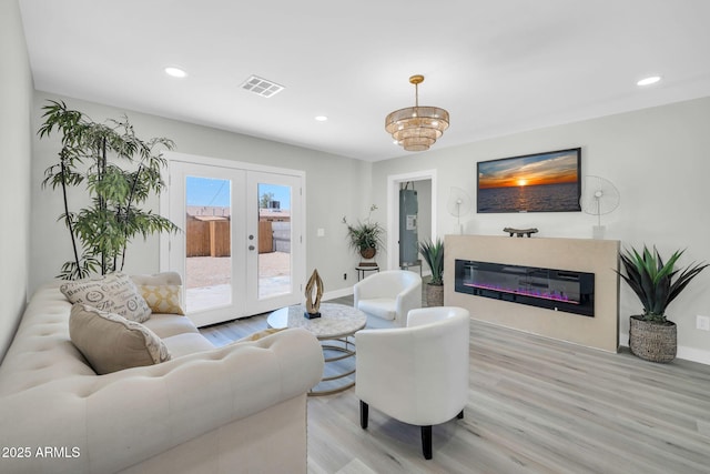 5236 S 19th Ave, Phoenix, AZ 85041 - living room with light wood-style floors, a glass covered fireplace, baseboards, recessed lighting, and french doors