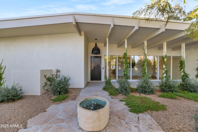 entrance to property featuring stucco siding