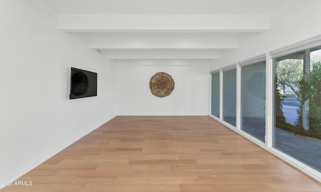 unfurnished sunroom featuring beamed ceiling