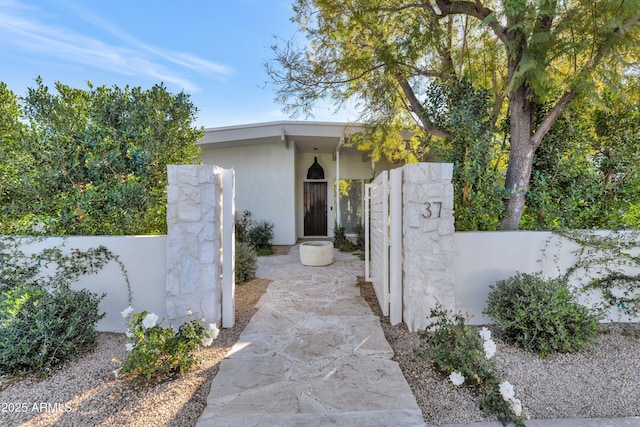 view of home's exterior featuring a gate, fence, and stucco siding