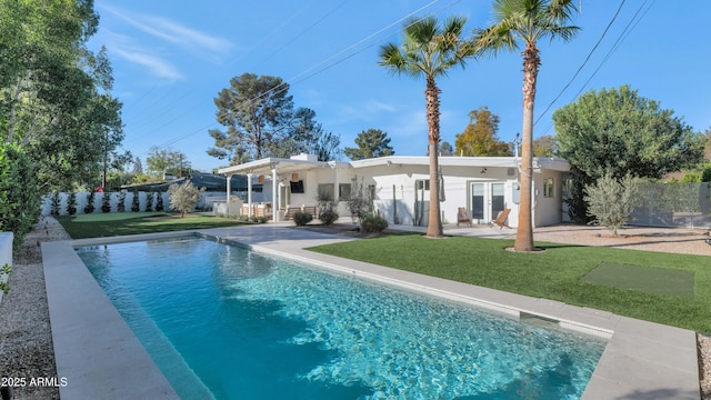 back of property featuring stucco siding, a lawn, a patio, and fence