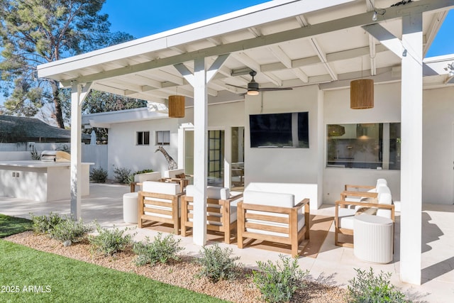 view of patio / terrace featuring ceiling fan, an outdoor hangout area, and an outdoor kitchen