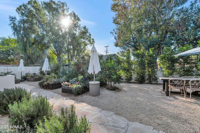 view of yard featuring a patio area, a vegetable garden, and fence