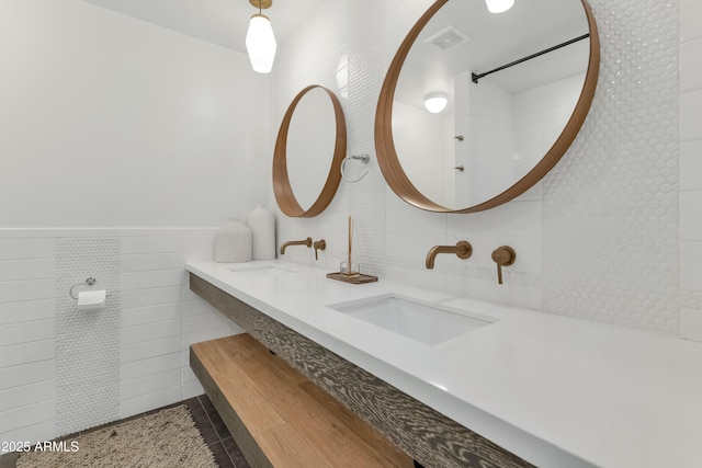 bathroom with tile patterned floors, visible vents, tile walls, and vanity