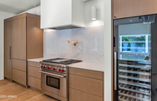 kitchen with premium range, wine cooler, light countertops, and custom exhaust hood