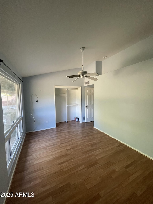 unfurnished bedroom featuring dark hardwood / wood-style floors, ceiling fan, and a closet