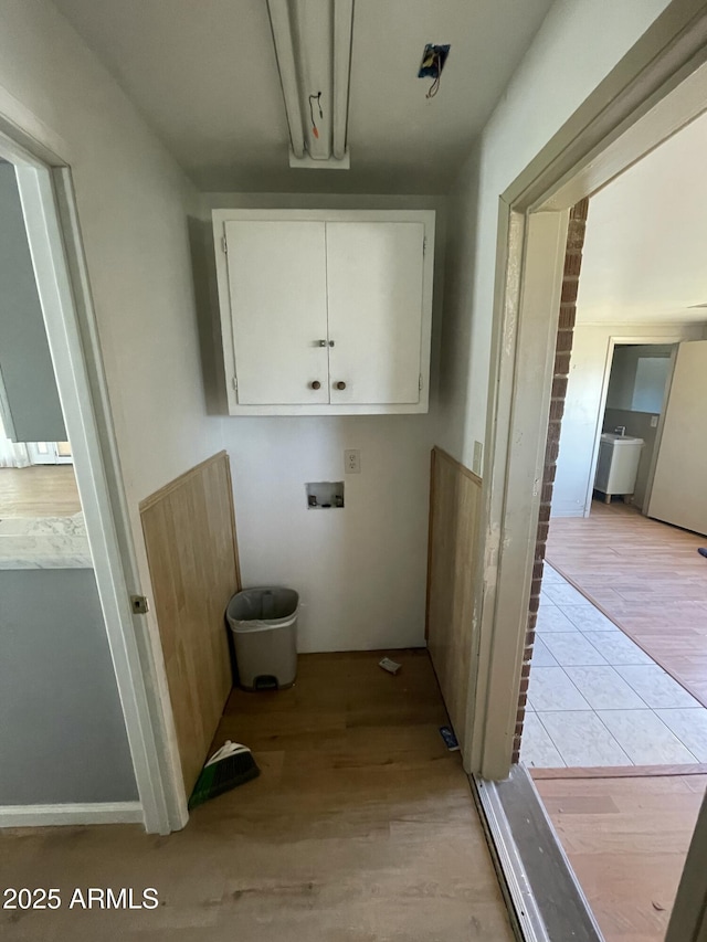 laundry room with washer hookup, cabinets, and light wood-type flooring