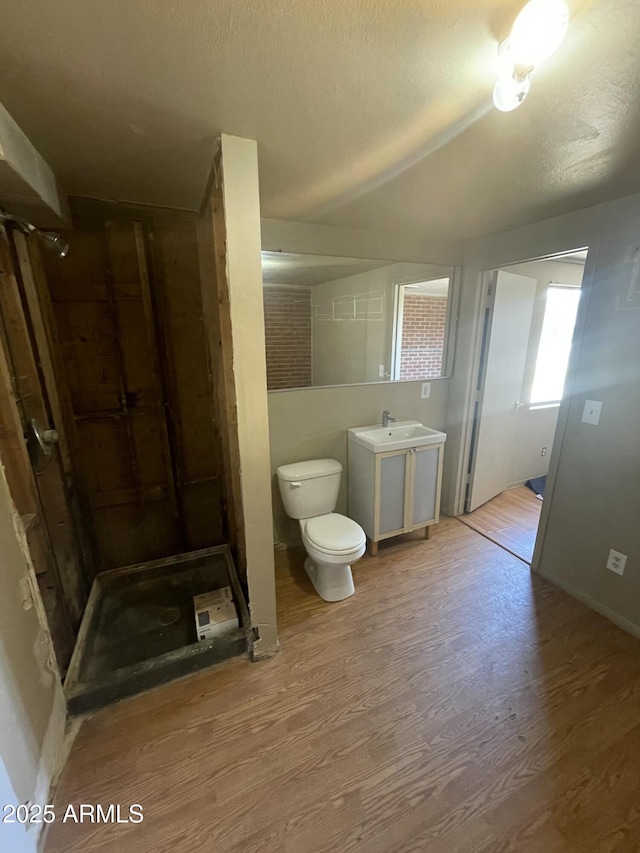 bathroom with walk in shower, toilet, wood-type flooring, a textured ceiling, and vanity