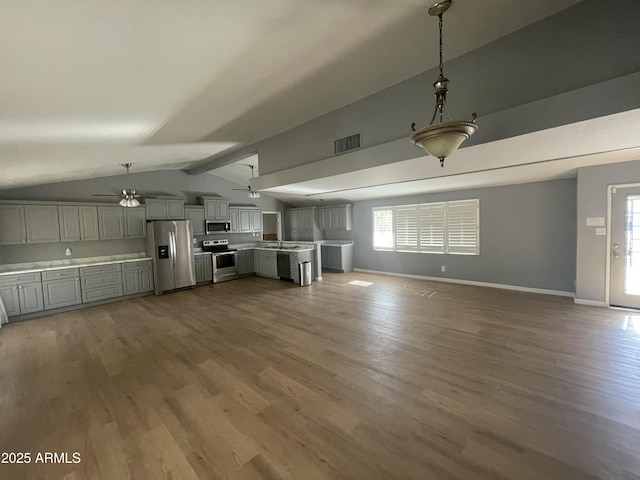 unfurnished living room with ceiling fan, hardwood / wood-style floors, and vaulted ceiling with beams