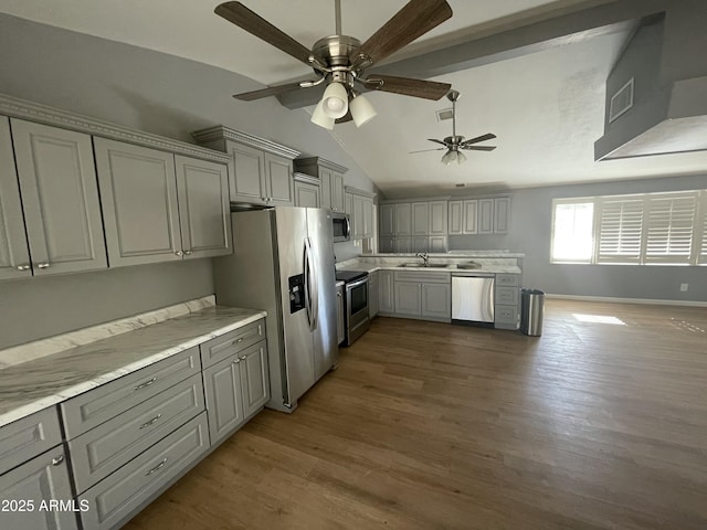 kitchen with lofted ceiling, sink, gray cabinetry, appliances with stainless steel finishes, and dark hardwood / wood-style flooring