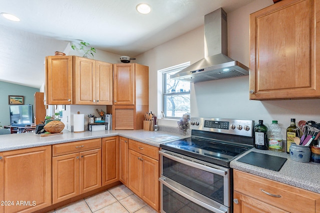 kitchen with light tile flooring, wall chimney exhaust hood, and electric stove